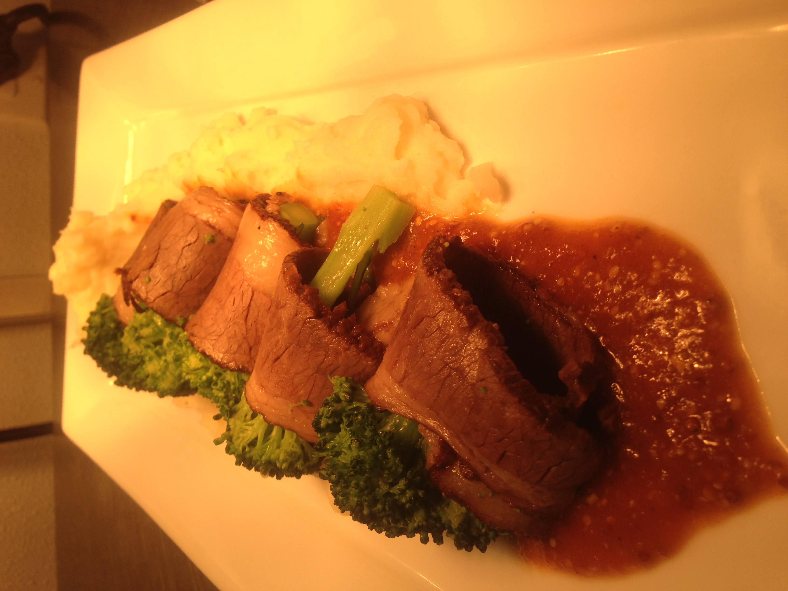 Braised beef brisket with mustard sauce, broccoli, and mashed potatoes