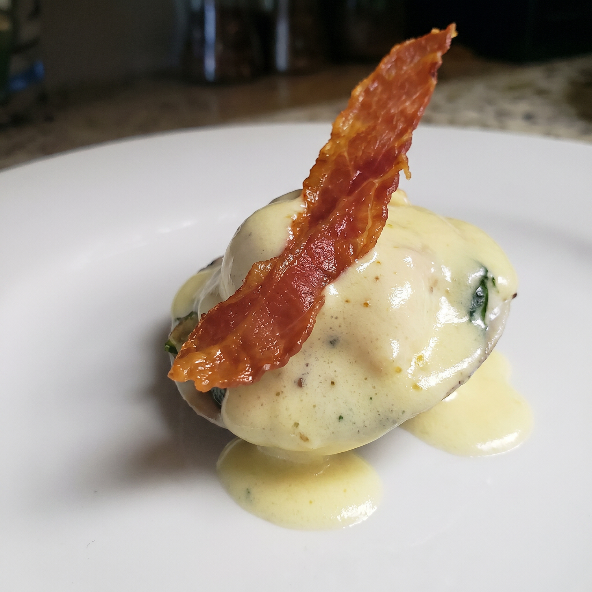 Steamed clams topped with hollandaise and crispy prosciutto
