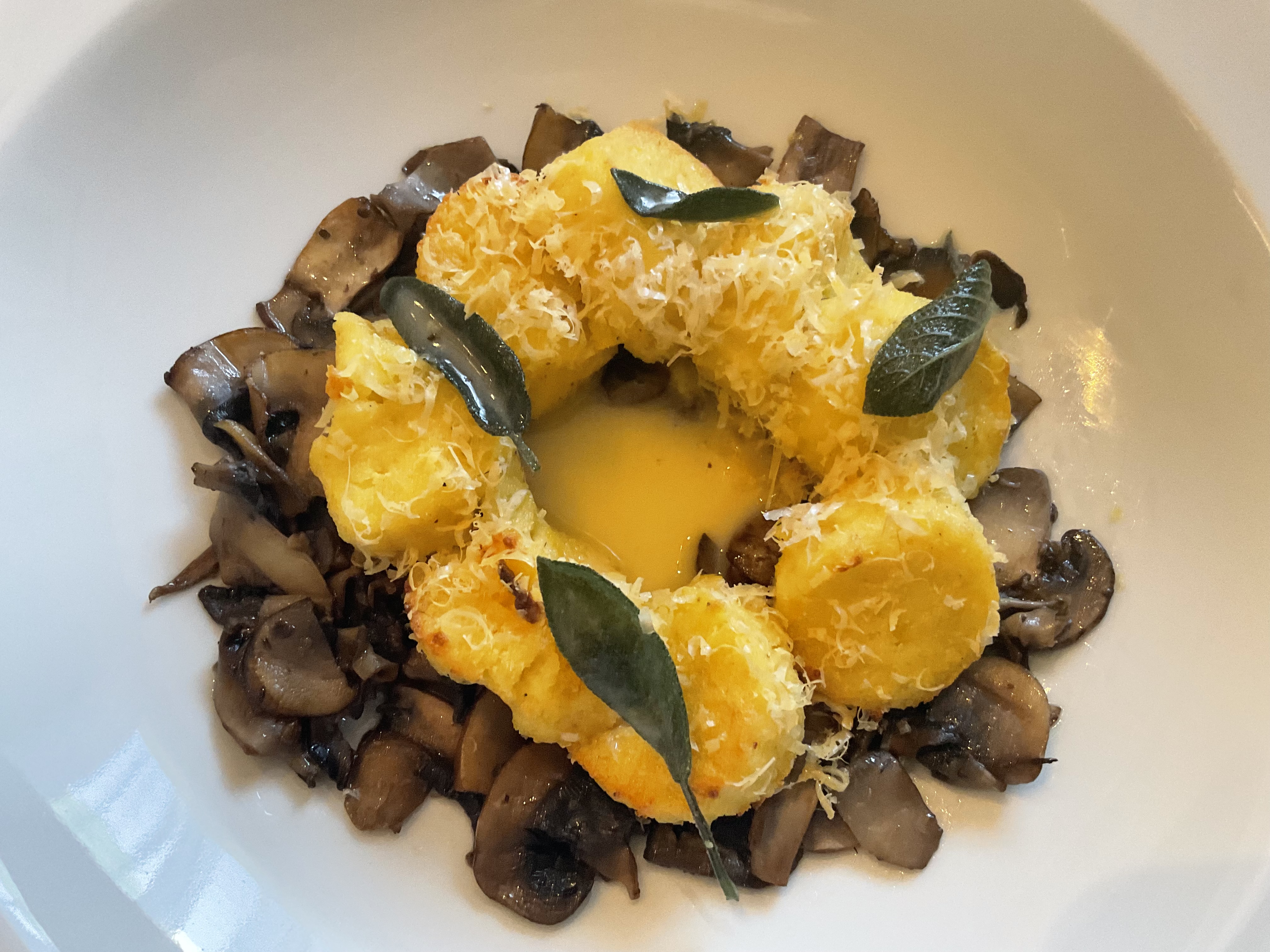 Pumpkin Roman Gnocchi baked and served over sautéed mushrooms with sage brown butter