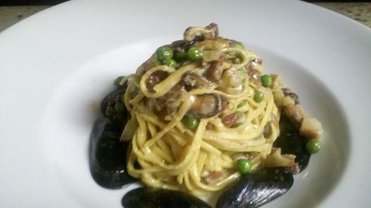 Spaghetti chitarra with black mussel carbonara, guanciale and peas