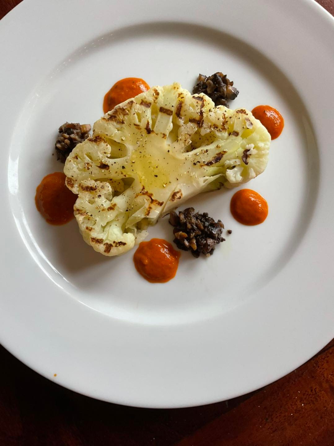 Grilled cauliflower steak with mushroom confit and roasted red pepper coulis