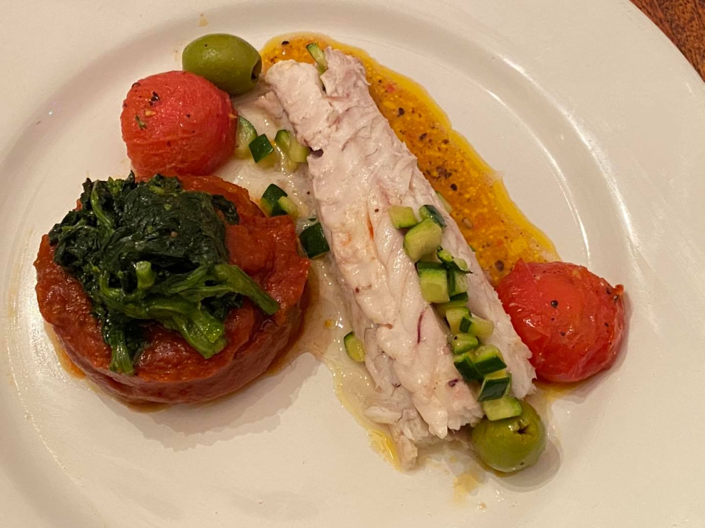 Baked branzino fillet with zucchini confiture, mushrooms, potatoes, and olives