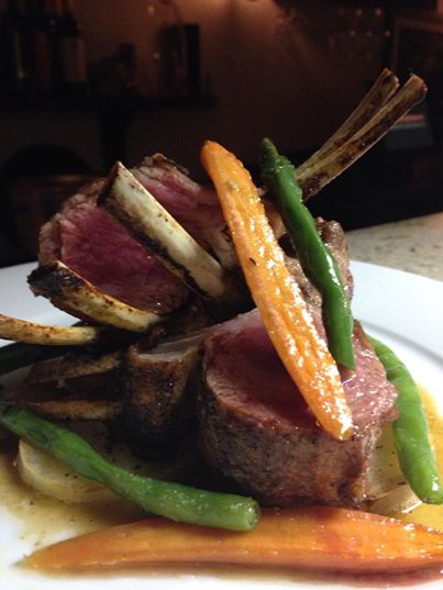 Pan-roasted rack of lamb with baked potatoes and seasonal vegetables