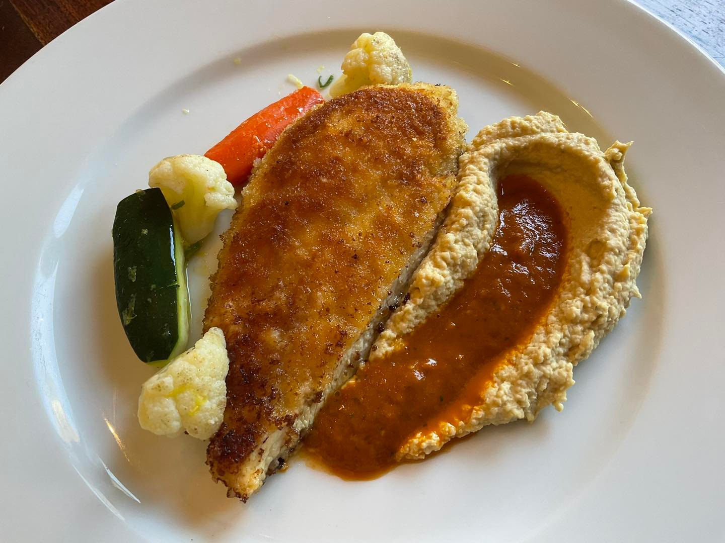 Chicken Milanese with garbanzo purée, roasted pepper sauce, and Tuscan vegetables